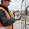 Operarios haciendo el control horario en obra al fichar la entrada de la jornada